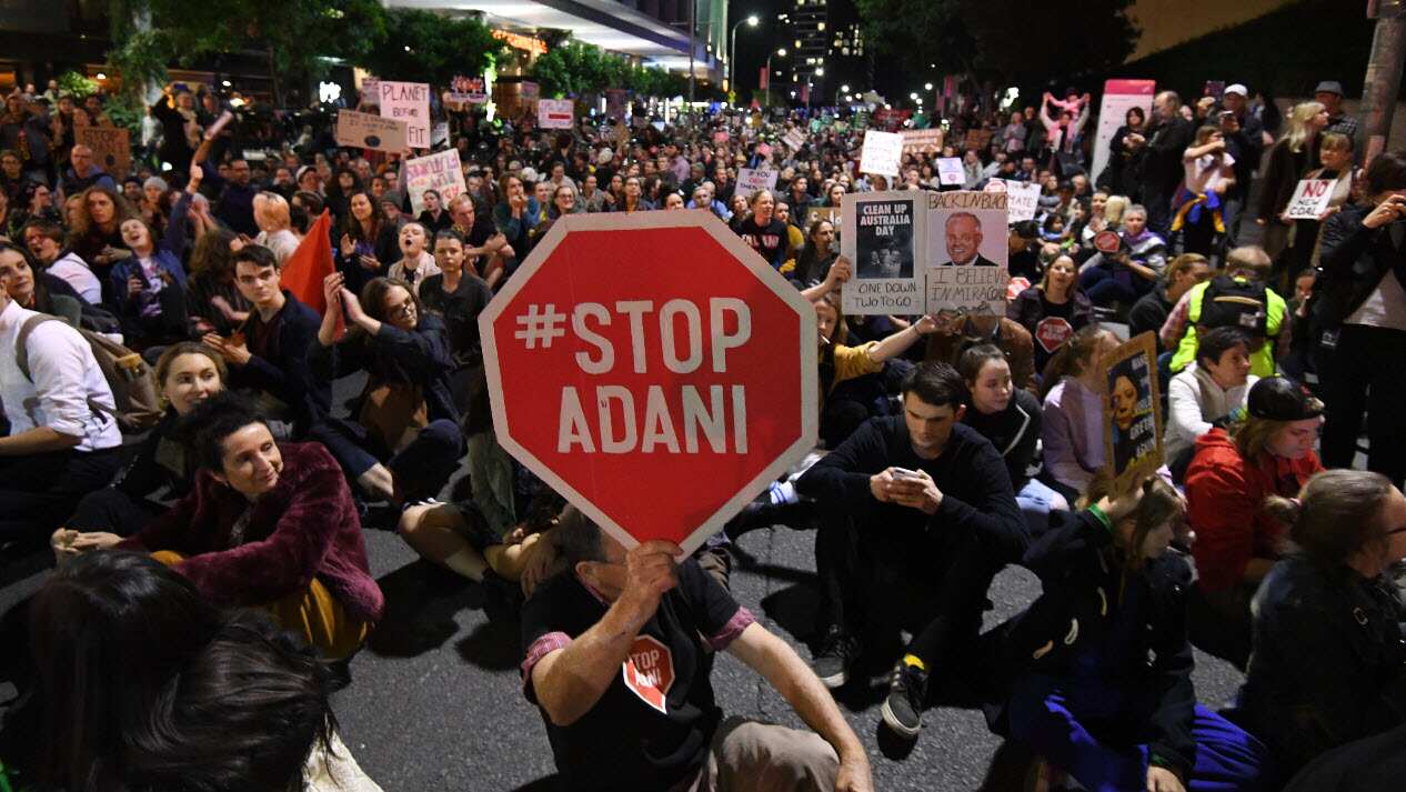 Protesters opposing to the construction of the Adani coal mine block a main road in Southbank during a rally in Brisbane.
