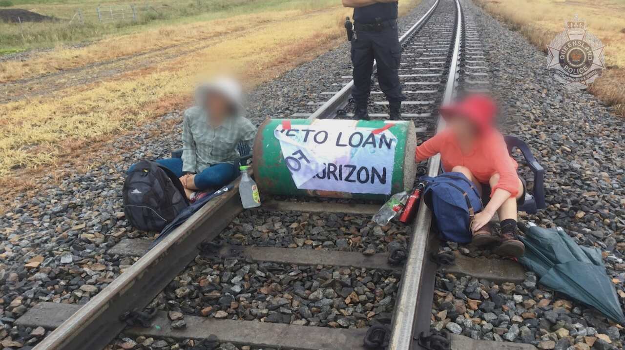 Environmental protesters blocking a rail line with a dragon's den lock-on device