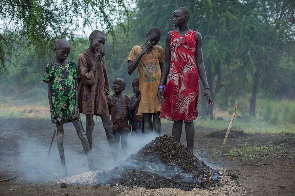 After the storm, children huddle around burning cow dung to keep warm. (Matthew Abbott)