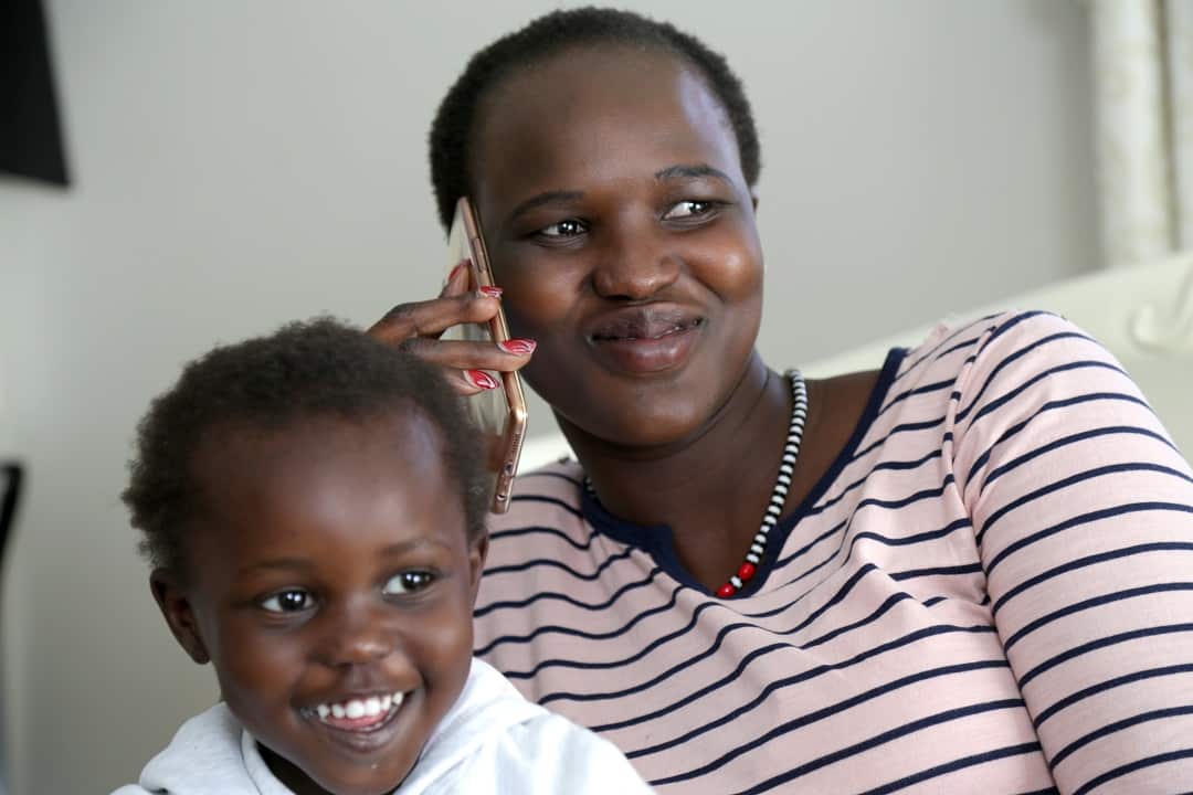 Mary speaking on the phone with her mother in Uganda.