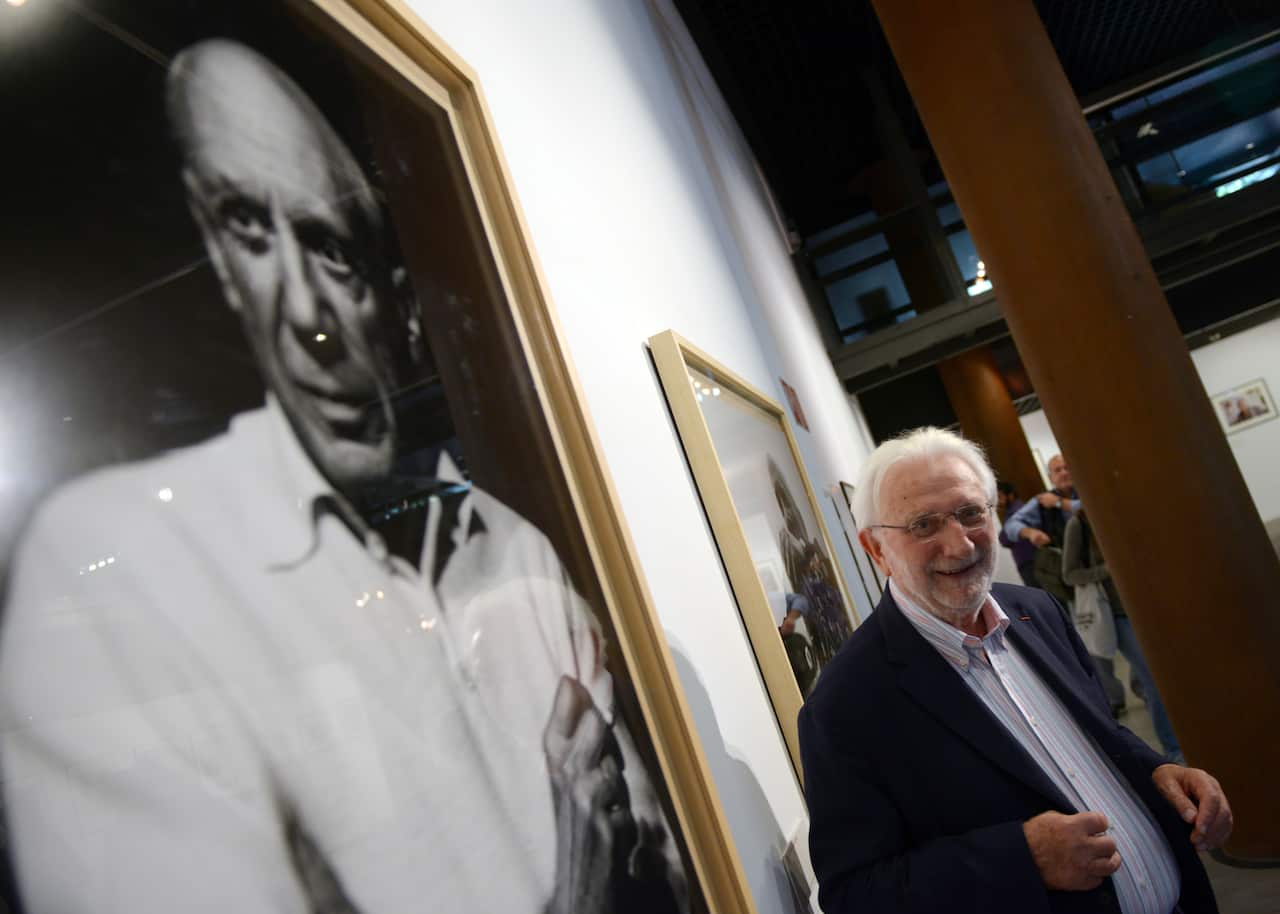 French photographer Lucien Clergue poses next his pictures of Spanish painter Pablo Picasso