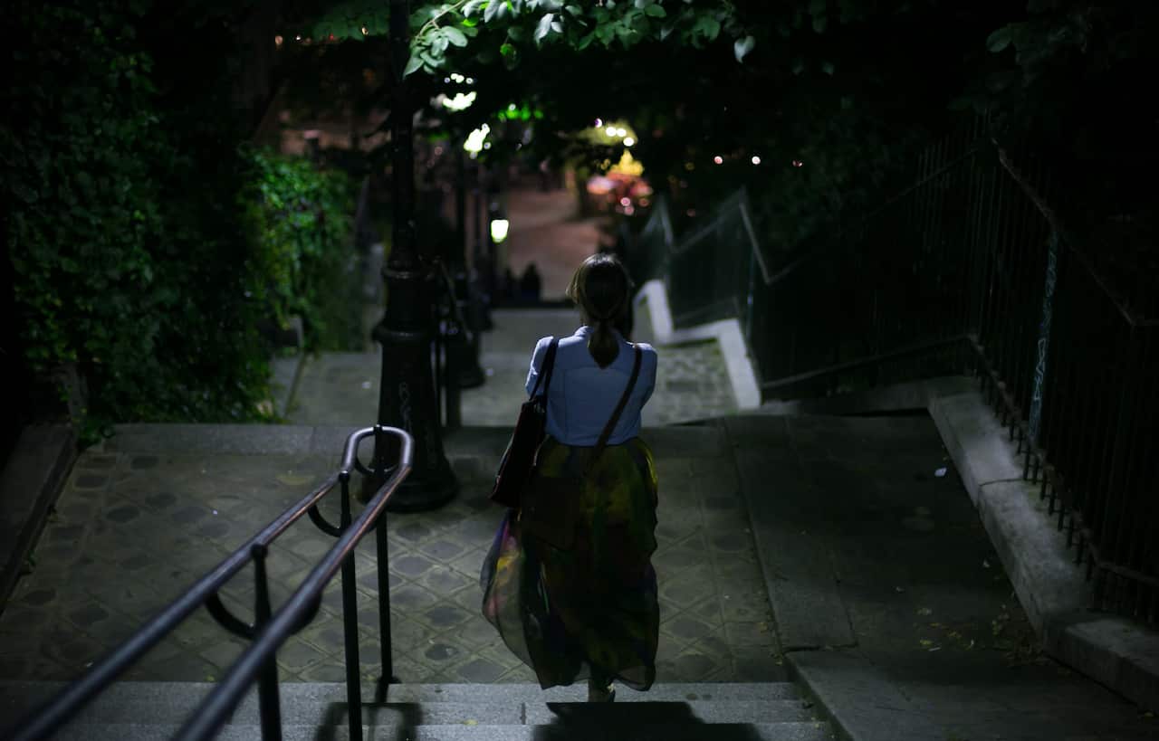 Rear View Of Woman Walking On Steps At Night