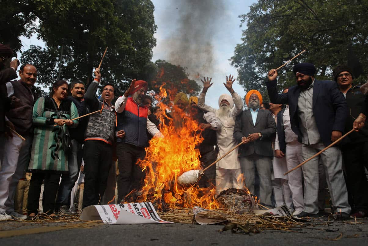 Sikh protestors burn effigies of congress party leaders Sajjan Kumar and Kamal Nath during a protest in New Delhi