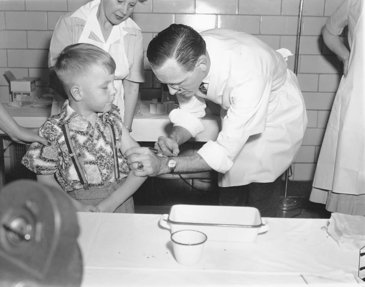 A file photo of Dr. Richard Mulvaney injecting the new polio vaccine into six-year-old Randall Kerr, the first of some 100 children to be innoculated at McLean in Washington, D.C. on April 26, 1954. Polio has since been eradicated in the US. (AP Photo)