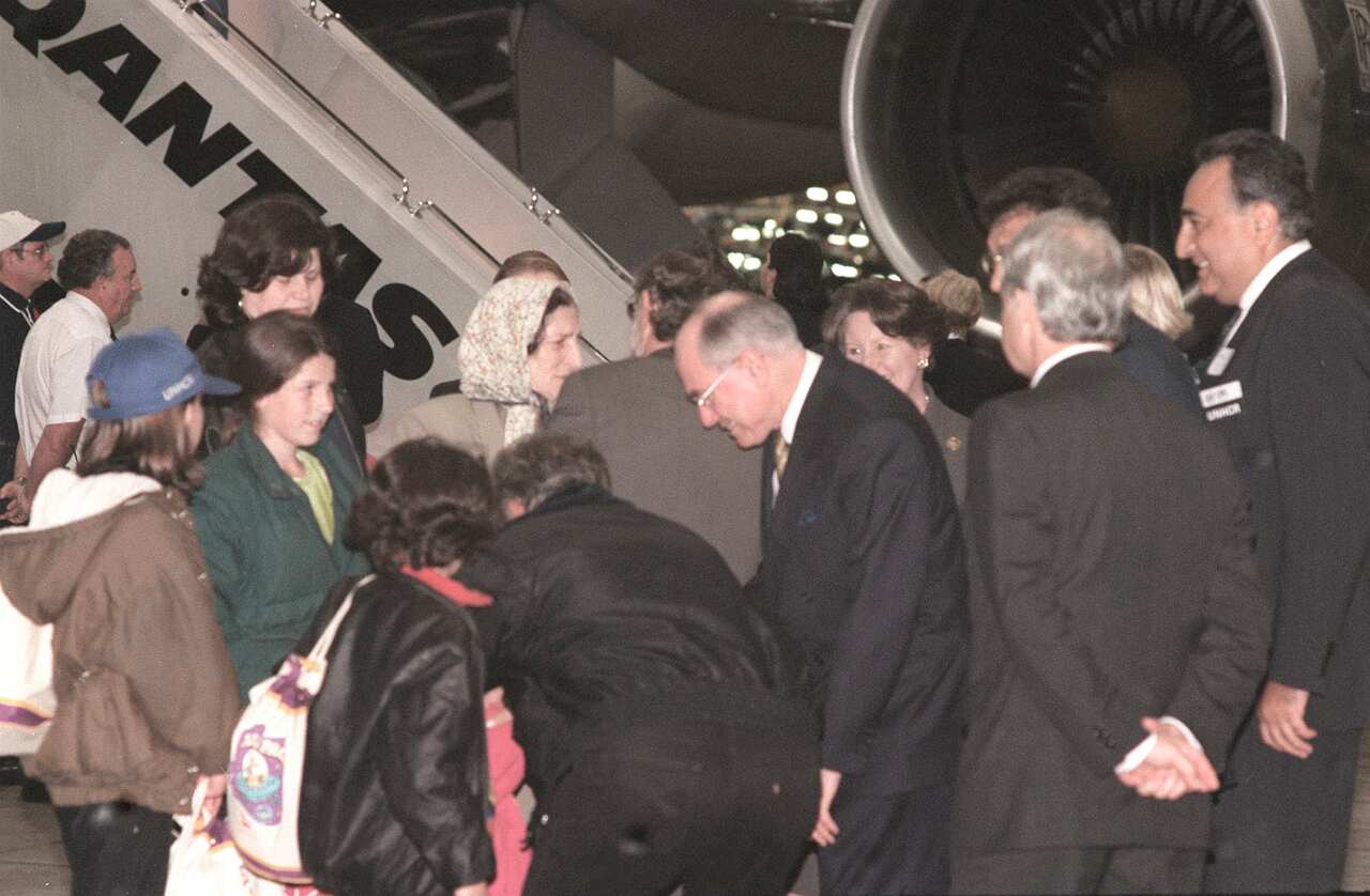 (VO330) SYDNEY, 7TH MAY, 1999. Australian Prime Minister John Howard and Immigration Minister Philip Ruddock greet some of the newly arrived Kosovo refugees at Sydney airport. (AAPIMAGE/VERONICA CASETTA)