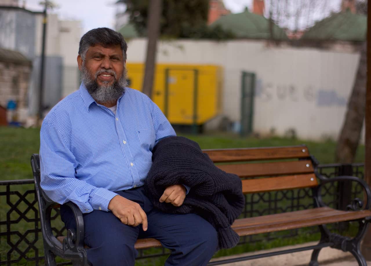 A man sitting outside on a bench.