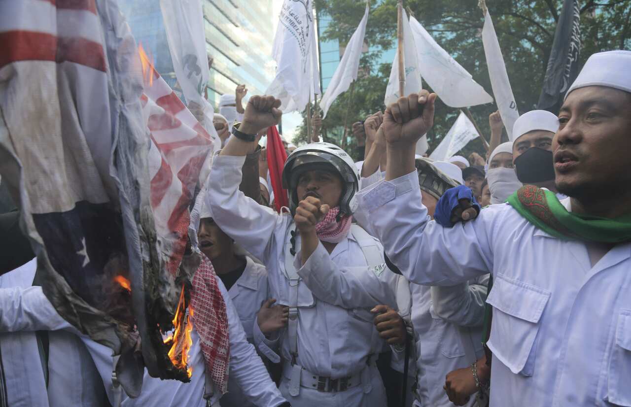 Members of the militant Islamic Defenders Front (FPI) burn a mock Australian and US flags during a demonstration outside Australian Embassy in Jakarta in 2013.