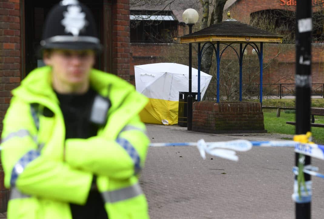 A police officer stands guard next to the sealed off bench where former Russian spy Sergei Skripal and his daughter Yulia collapsed in Salisbury