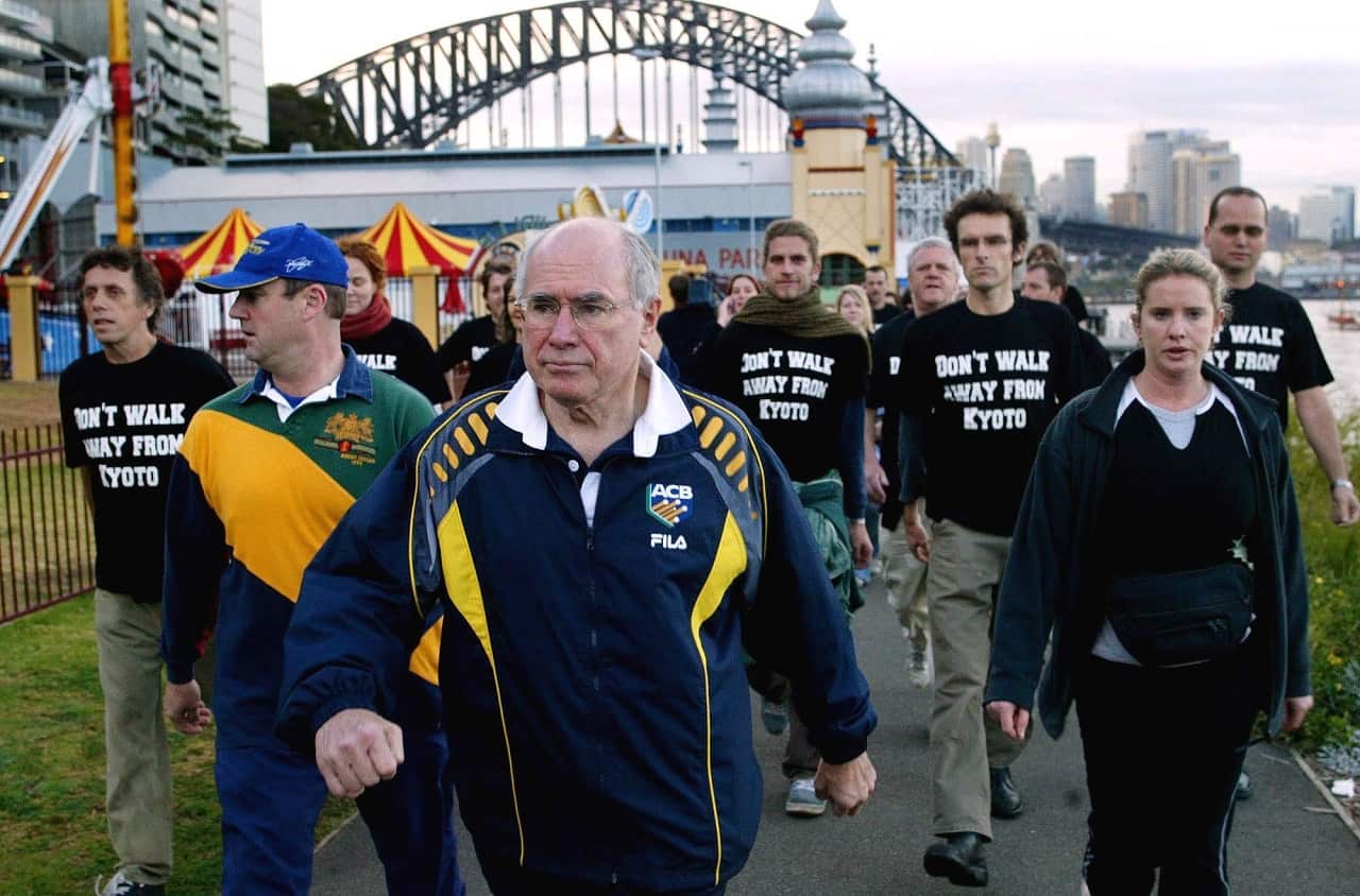 Protesters wearing shirts that read "don't walk away from Kyoto" follow then-PM John Howard.