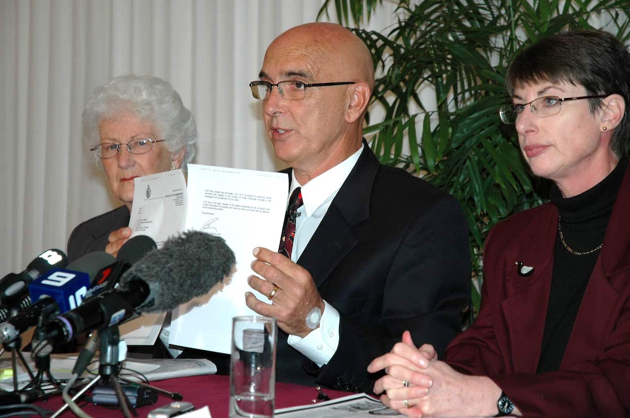 John Quigley holds up a letter of apology from WA police to Andrew Mallard in Perth, 2006. Mr Quigley is flanked by Mr Mallard's mother Grace and sister Jacqui.