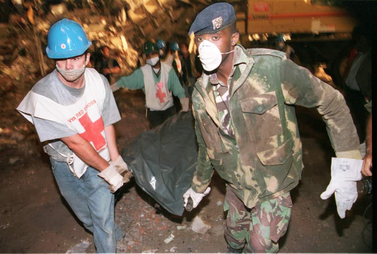 Members of the Red Cross and Kenyan military remove a body from the collapsed building next to the US embassy in Nairobi Tuesday, 11 August, 1998.