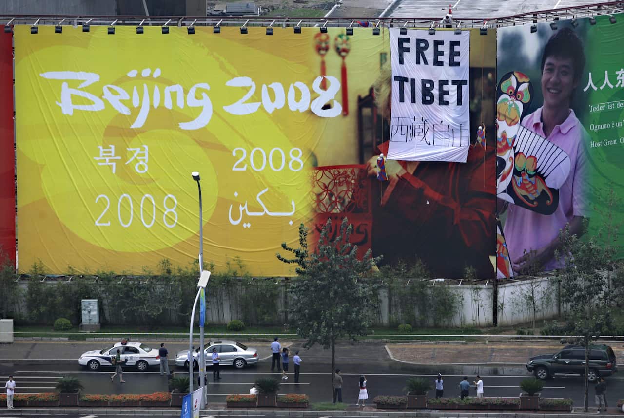 Pro Tibet activists unfurled a "Free Tibet" banner and Tibetan flags on top of a Beijing Olympics billboard