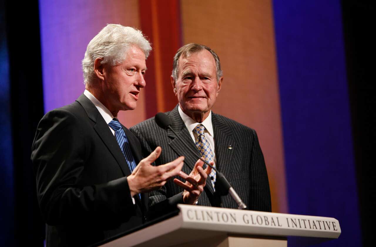 Former President George H.W. Bush, right, shakes hands with former President Bill Clinton in this file photo from 2008. 