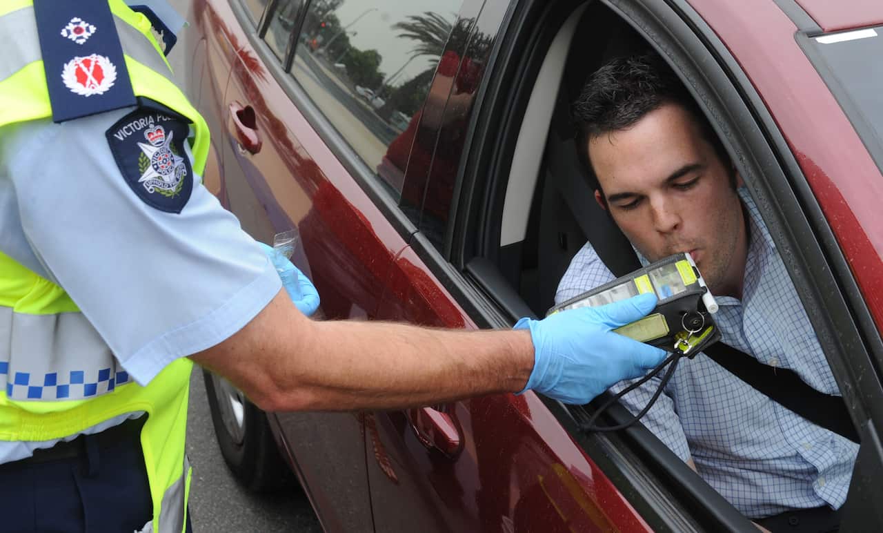 Police perform a random breath test (RBT) on a driver in the Docklands precinct in Melbourne, Friday, Nov. 20, 2009. Victoria police today launched the the road safety initiative "Operation Raid". (AAP Image/Julian Smith) NO ARCHIVING