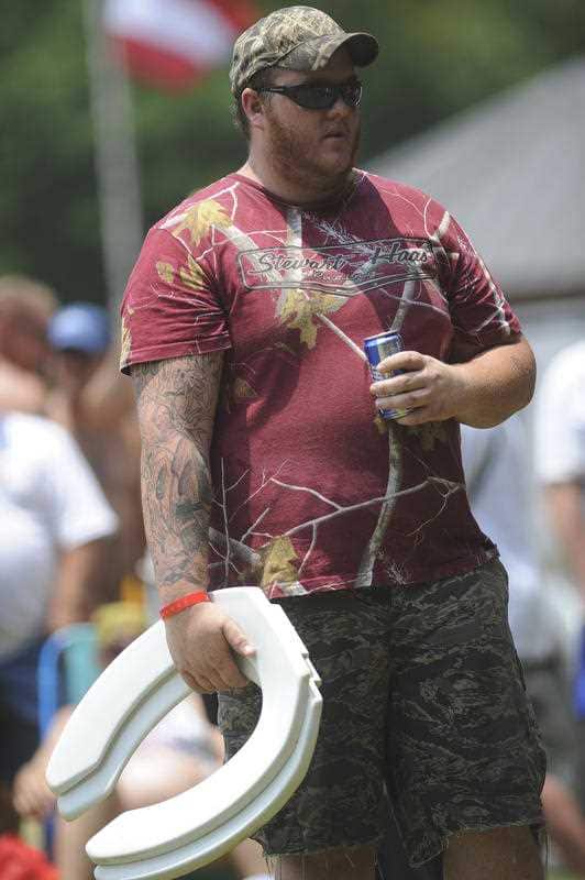 A participant prepares to throw a toilet seat during the toss competition at 2011 Redneck Games.