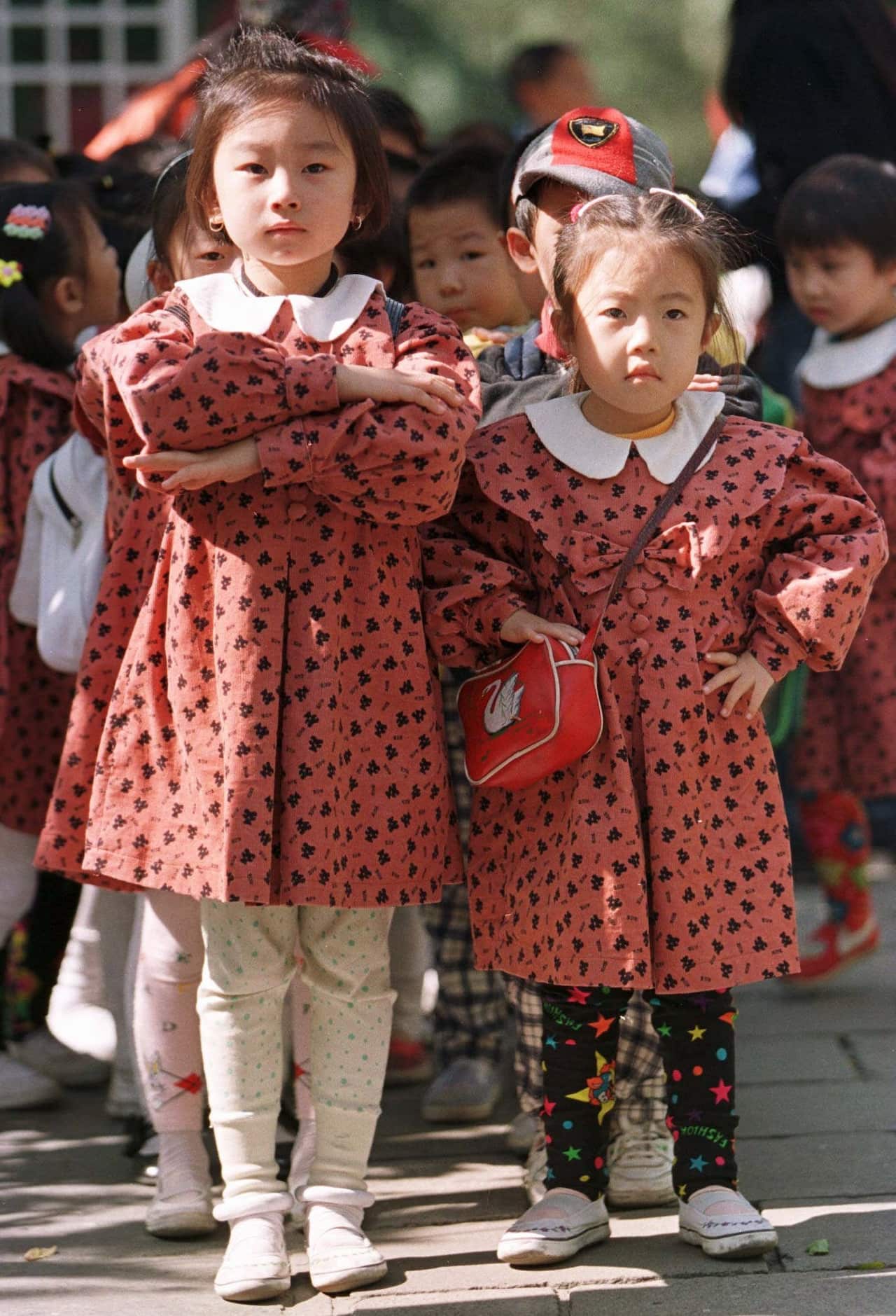 Young girls take their positions to lead their daycare on an outing in Beijing Monday October 13, 1997. 