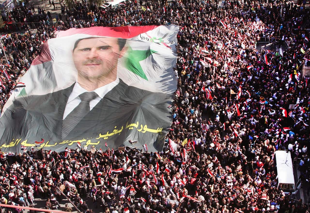 Pro-Syrian regime protesters carry a huge portrait of Syrian President Assad in 2011.