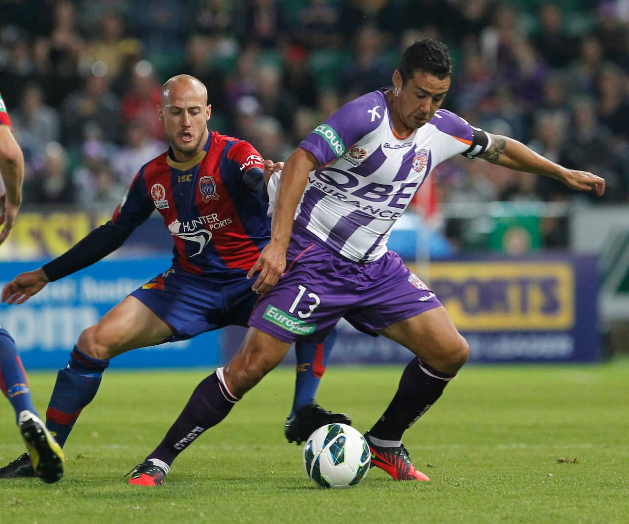 Perth Glory's Travis Dodd (right) evades a tackle from Newcastle Jets' Ruben Zadkovich.