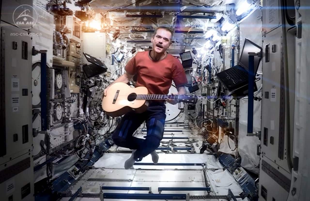 astronaut Chris Hadfield performing aboard the International Space Station a revised version of David Bowie's song Space Oddity in 2013.