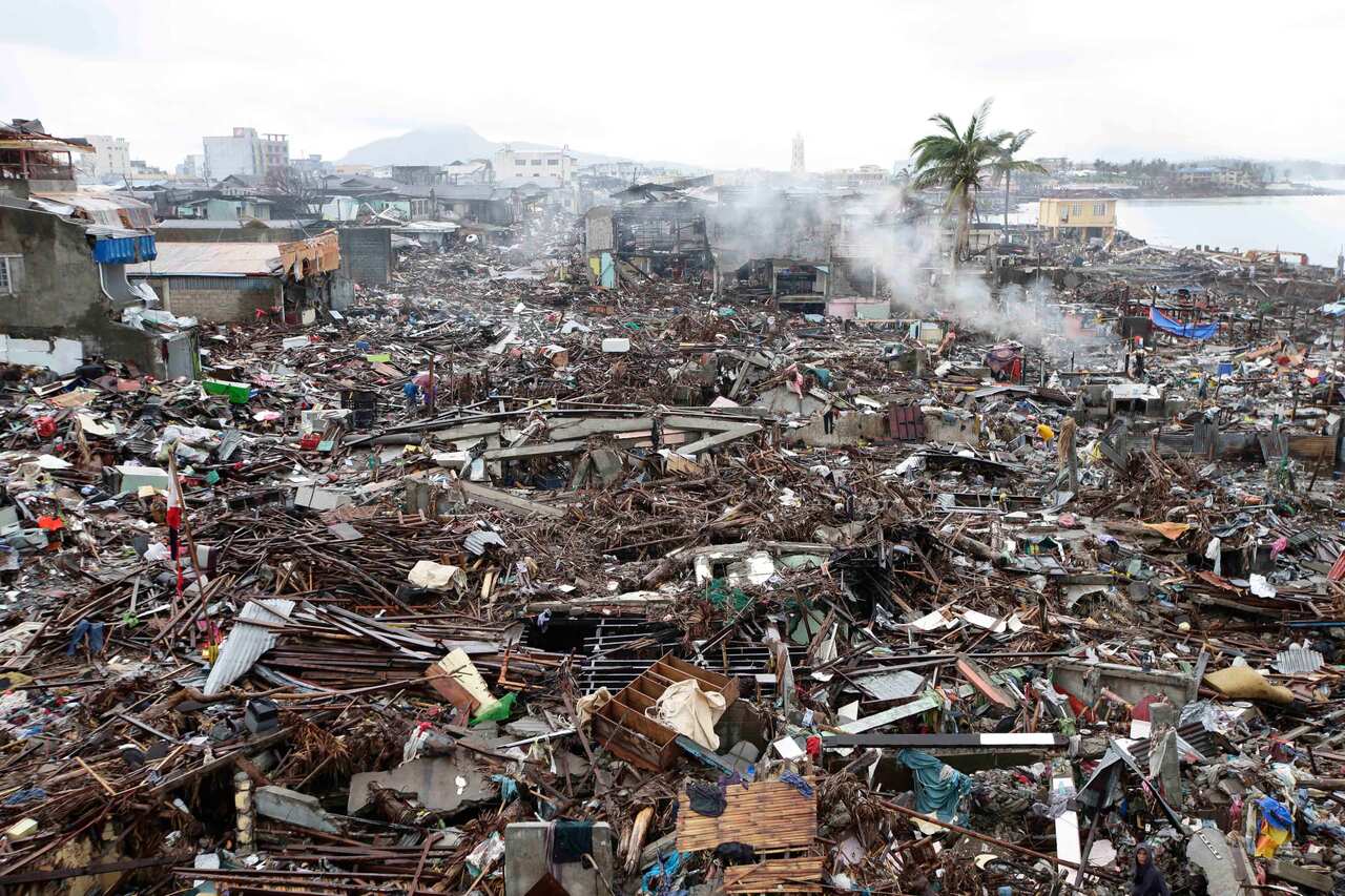 Typhoon survivors sift through the debris which were washed inland by Typhoon Haiyan in central Philippines in 2013. 
