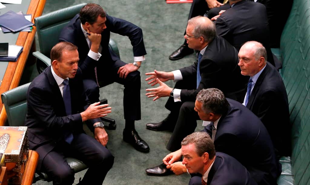 Prime Minister Tony Abbott talks to his front bench during the House of Representatives Qantas debate at Parliament House in Canberra, Thursday, March 6, 2014. (AAP)