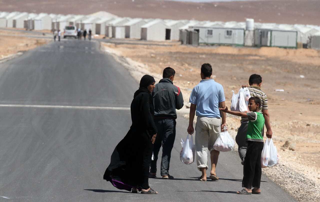 A Syrian refugee family walks towards the new Syrian camp of Azraq, which stretches for 9 miles, Wednesday, April 30, 2014.