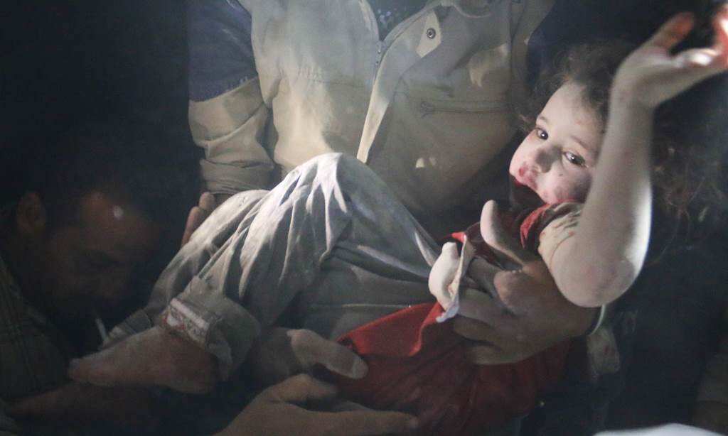 Syrian rescue workers pull out a girl from the rubble following reported barrel bombs attacks by government forces in the northern city of Aleppo, late on June 1, 2014. (AFP)