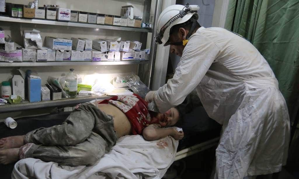 A Syrian medic treats an injured girl following reported barrel bombs attacks by government forces in the northern city of Aleppo, late on June 1, 2014. (AFP)