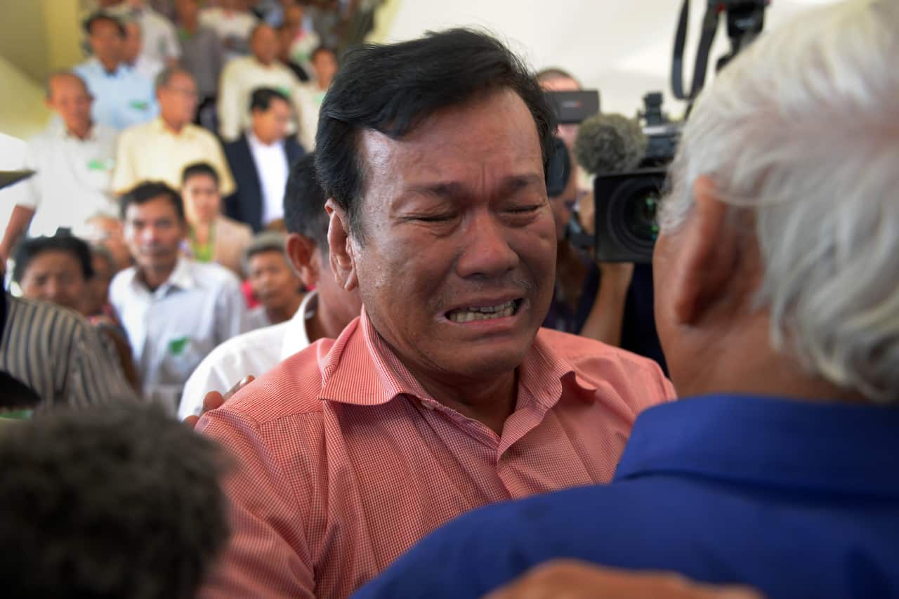 Soum Rithy (C), a Cambodian survivor of the Khmer Rouge, cries as he hugs Chum Mey (R), a prominent survivor of Tuol Sleng prison (S-21), after hearing the verdict (AAP)