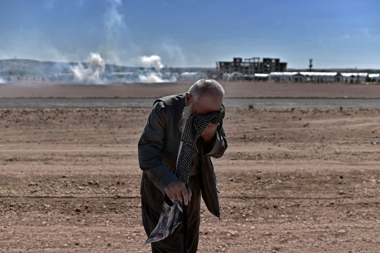 A Kurdish man reacts to tear gas during a clash between Turkish soldiers and Kurdish protesters near the Mursitpinar border crossing on the Turkish-Syrian border. (AFP)