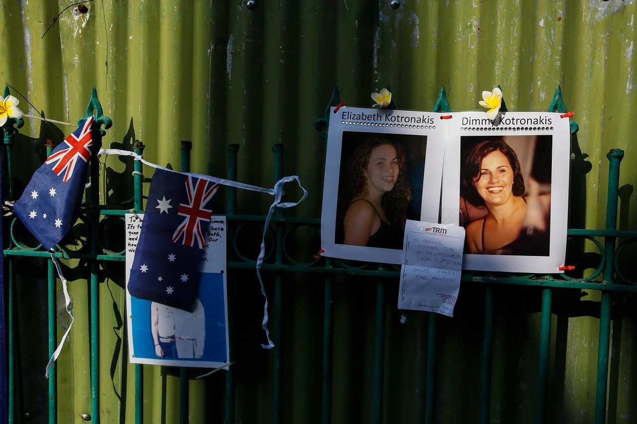 Pictures of 2002 Bali bomb victims are attached on a fence at the former site of the Sari Club.