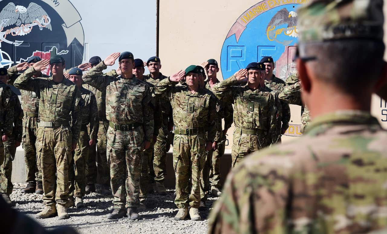 British soldiers and US Marine Corps soldiers attend a ceremony of the British, US and NATO flags being lowered at the Camp Bastion-Leatherneck complex in 2014.