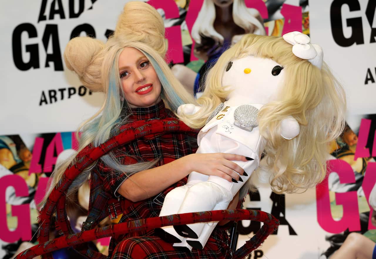 Lady Gaga poses for photographers with a Lady Gaga version of Hello Kitty doll in December 2013 (AAP)