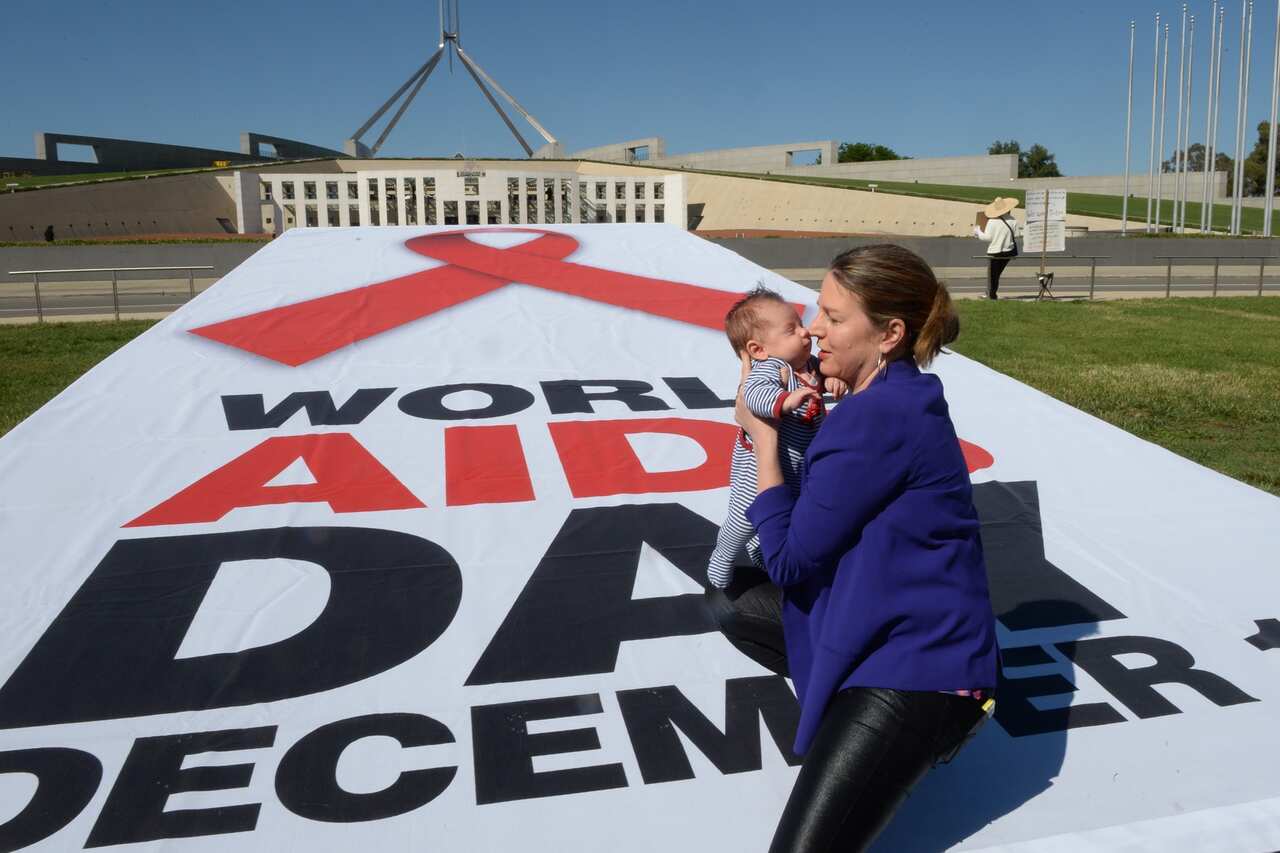 8 week old Jaster Pratt is held by mum Louise at a World Aids Day promotion at Parliament House in Canberra, Monday, Dec. 01, 2014. Jaster is the child of gay former West Australia Senator Louise Pratt. (AAP Image/Alan Porritt) NO ARCHIVING