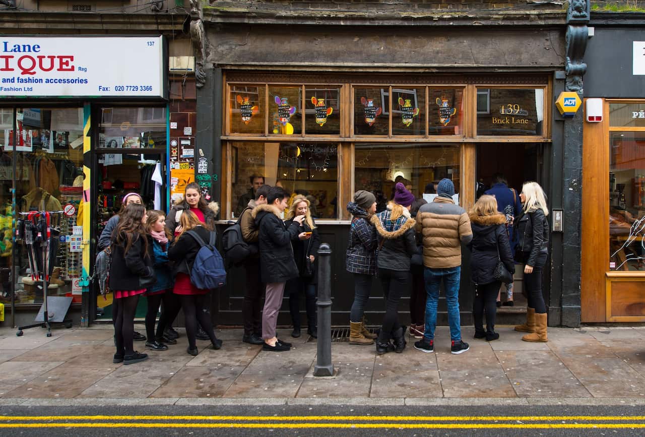 Customers queue outside the Cereal Killer cafe on Brick Lane, east London, which offers over 100 varieties of cereal from America, South Africa, France, Australia, South Korea and the UK.. Picture date: Friday December 12, 2014. Dominic Lipinski/PA Wire