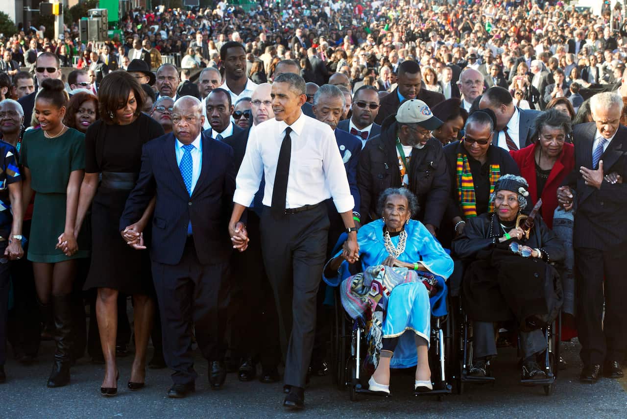 Former President Barack Obama, holds hands with Rep. John Lewis, left, marching on the 50th anniversary of 'bloody sunday' in Selma.