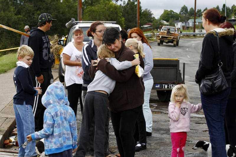Colleen Jones (centre) is consoled after losing her house during flooding in Dungog in the NSW Hunter region.