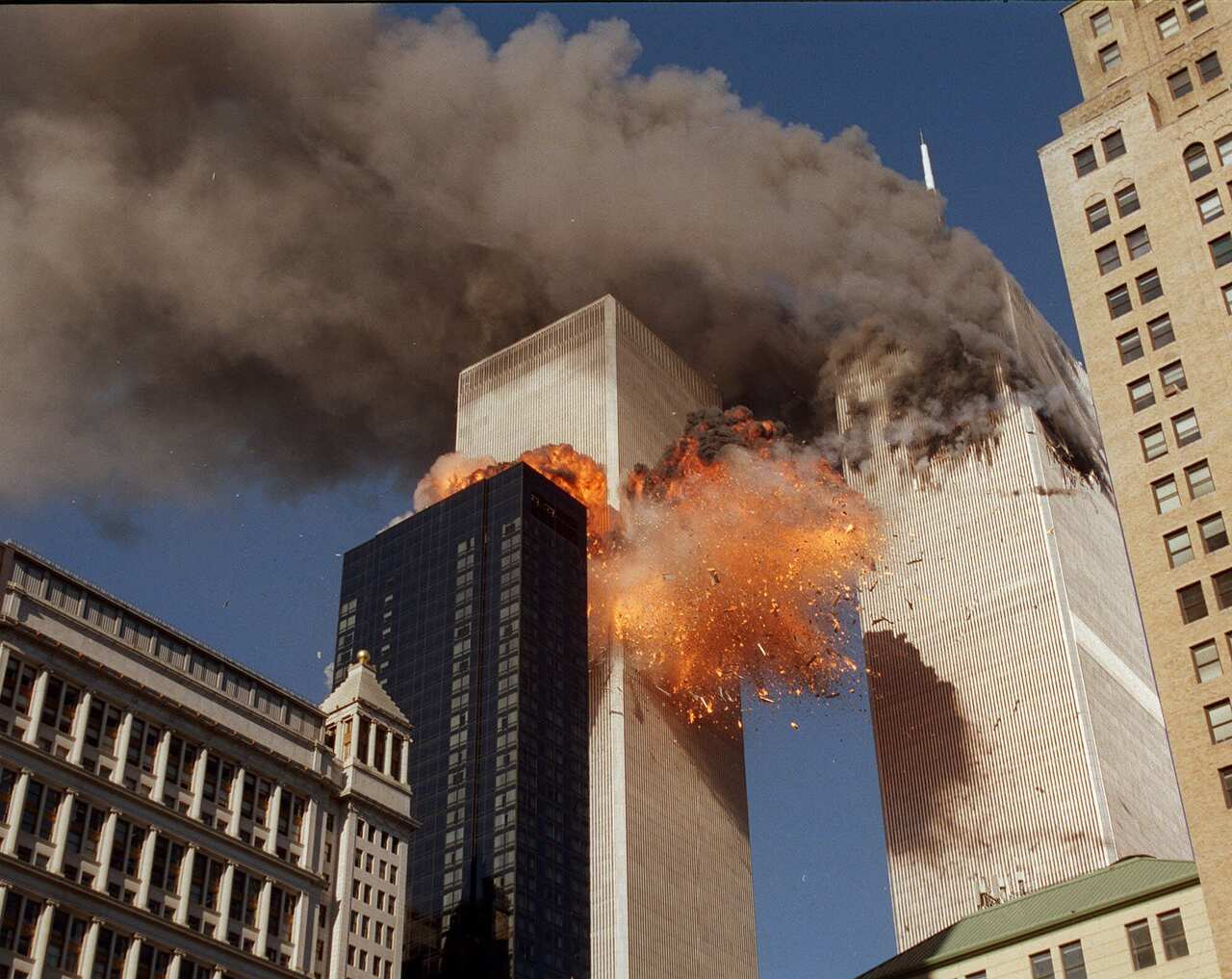 Smoke billows from one of the towers of the World Trade Center and flames and debris explode from the second tower.
