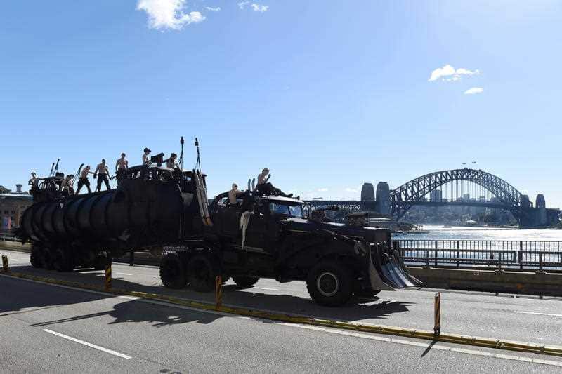 Cast members from the new Mad Max movie, Mad Max - Fury Road film a promo on the Cahill Express against the backdrop of the Sydney Harbour Bridge in Sydney, Wednesday,