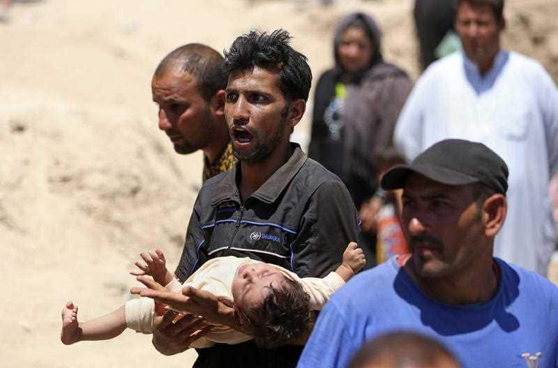  Displaced Iraqis from Ramadi cross the Bzebiz bridge after spending the night walking towards Baghdad, as they flee their hometown, 65 km west of Baghdad, Iraq, Saturday, May 16, 2015. (AAP)