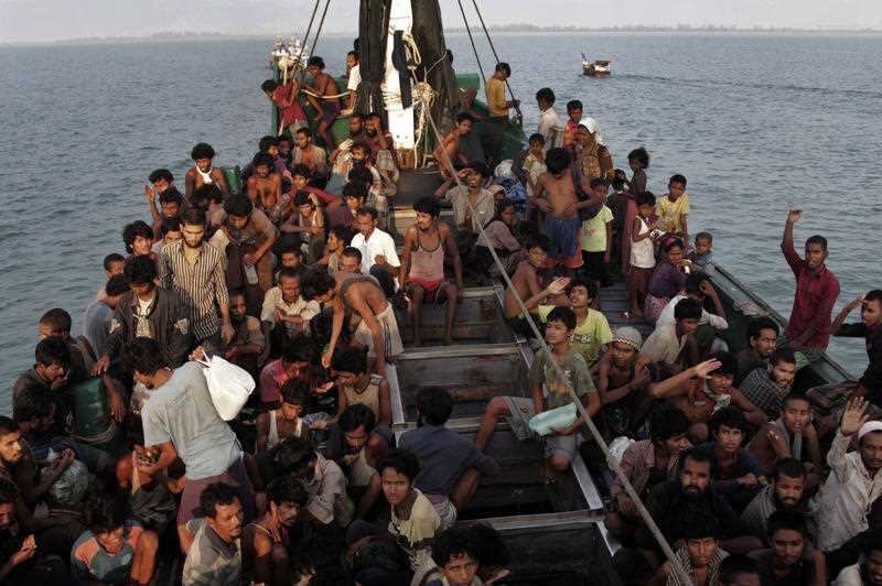 In this May 20, 2015 file photo, migrants wait to be be rescued by Acehnese fishermen on their boat on the sea off East Aceh, Indonesia.