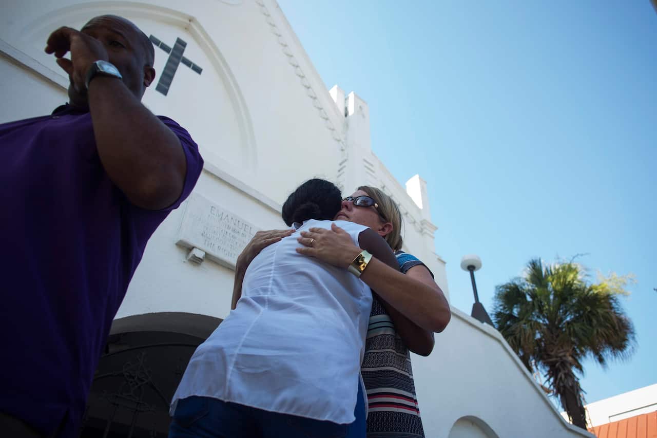 People are seen here hugging at the memorial site of the Emanuel African Methodist Episcopal (AME) Church where nine people were murdered in Charleston, South Carolina, USA, 18 June 2015. (EPA/JOHN TAGGART)