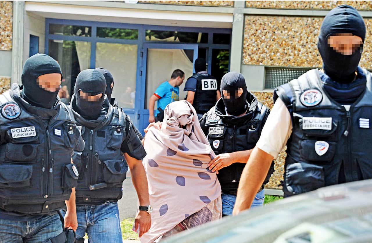 Police escort an unidentified woman as they search Yacine Salhi's home in Saint-Priest, near Lyon, arrested in connection with the attack, 26 June 2015. (EPA/RICHARD MOUILLAUD FRANCE OUT)