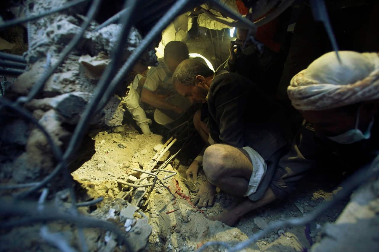 Men uncover the body of a girl under the rubble of a house destroyed by a Saudi-led airstrike in Sanaa, Yemen, Thursday, July 2, 2015