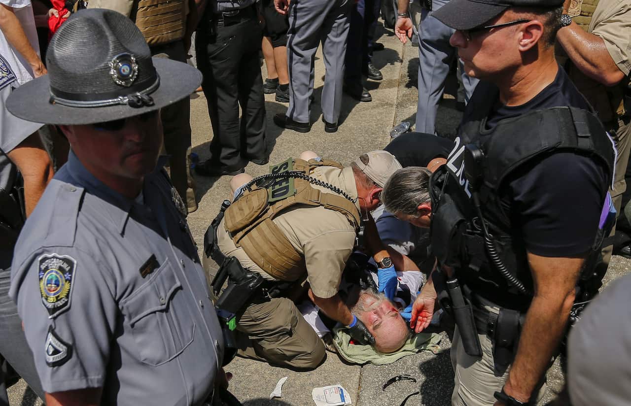 A man is treated after getting injured during New Black Panther Party and the Loyal White Knights of the Ku Klux Klan rallies (AAP)