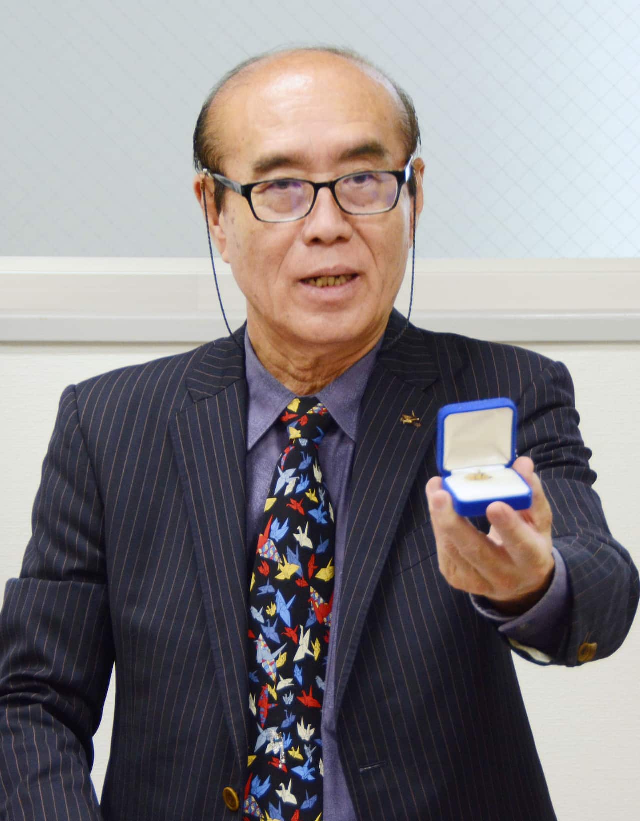 Masahiro Sasaki shows a paper crane folded by his late sister Sadako. 