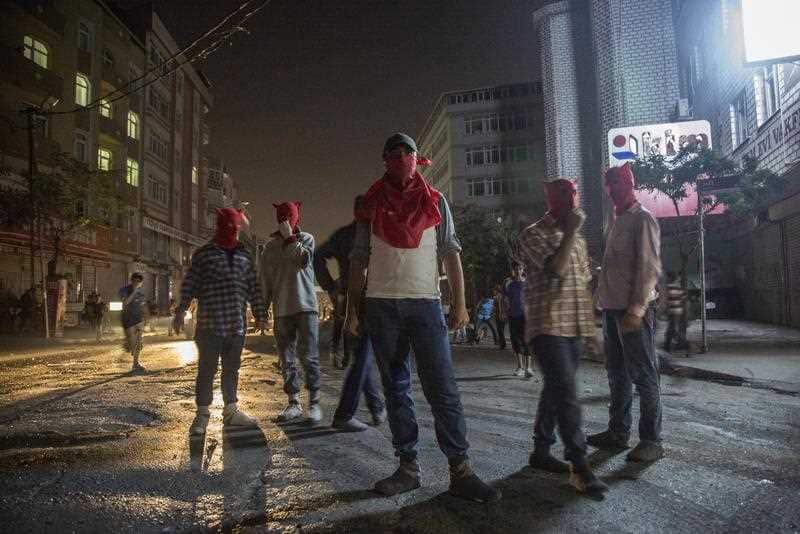 Protestors stand as they clash with Turkish police during an anti-government protest in Istanbul, Turkey, 19 August 2015. (AAP)