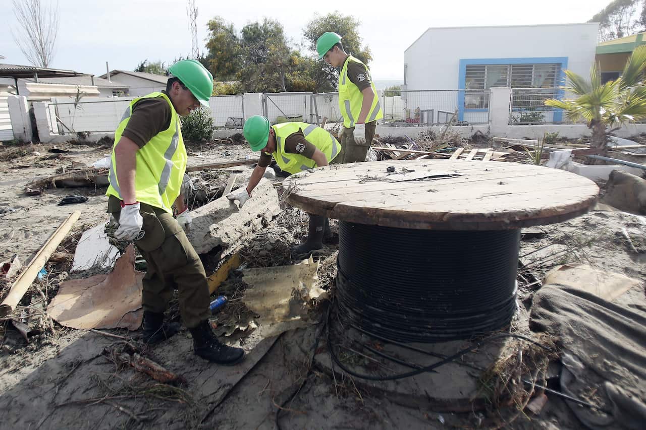 Chilean police remove debris after strong waves in the aftermath of a 8.3 magnitude earthquake that struck northern Chile, in port city of Tongoy