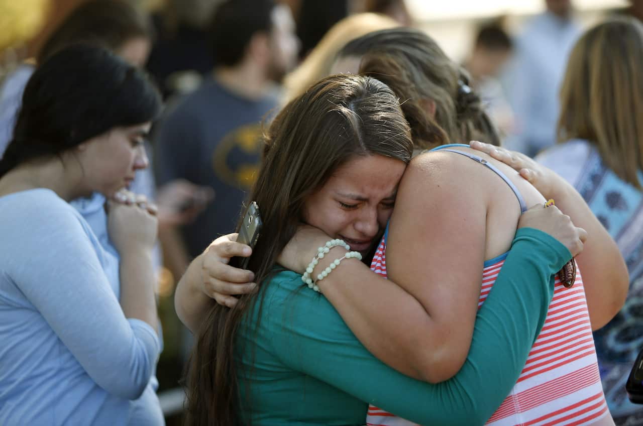 Jessica Vazquez, left, hugs her aunt, Leticia Acaraz, as they await word on Acaraz's daughter after a deadly shooting at Umpqua Community College, in Roseburg, Ore., on Thursday, Oct. 1, 2015. (Andy Nelson/The Register-Guard via AP) 