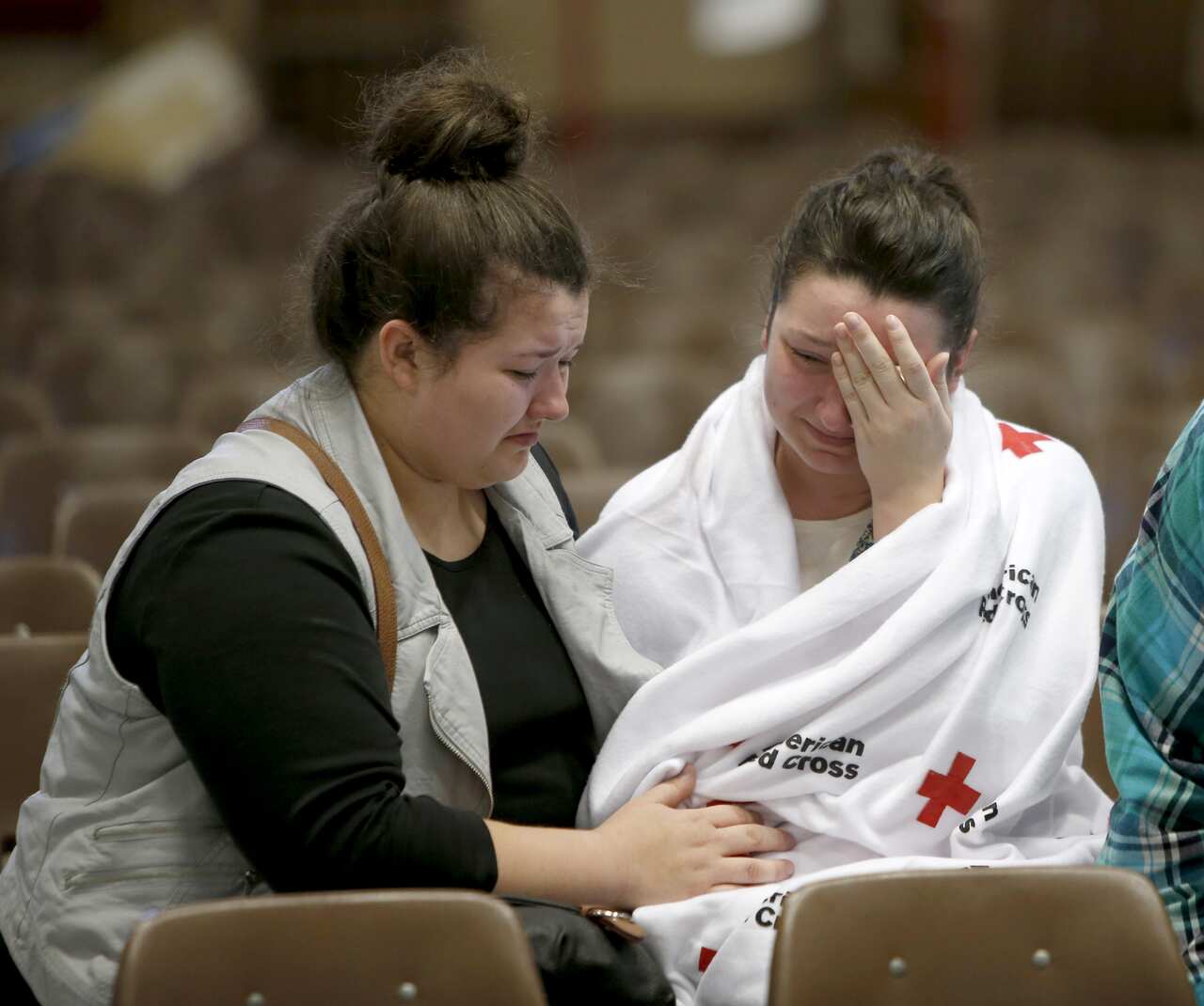 Hannah Miles, right, sits with her sister Hailey after Hannah was reunited with her family in Roseburg, Ore., on Thursday, Oct. 1, 2015, after a deadly shooting at Umpqua Community College. (Andy Nelson/The Register-Guard via AP) MANDATORY CREDIT
